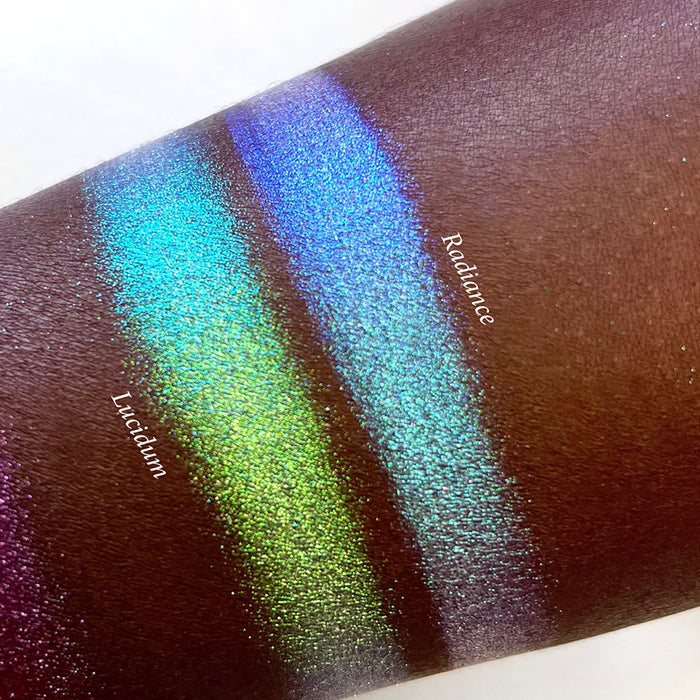 Top angled arm swatches on deep skin tone of Lucidum Series 2 Iridescent Multichrome eyeshadow shifts compared to Radiance