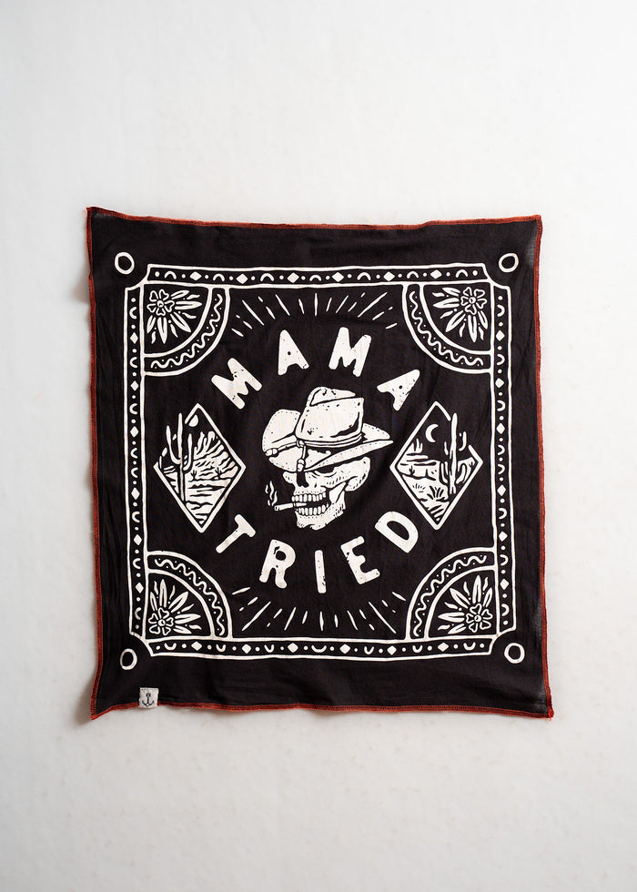 Black bandana with "Mama Tried" text, featuring a skull in a cowboy hat, surrounded by floral and geometric patterns.