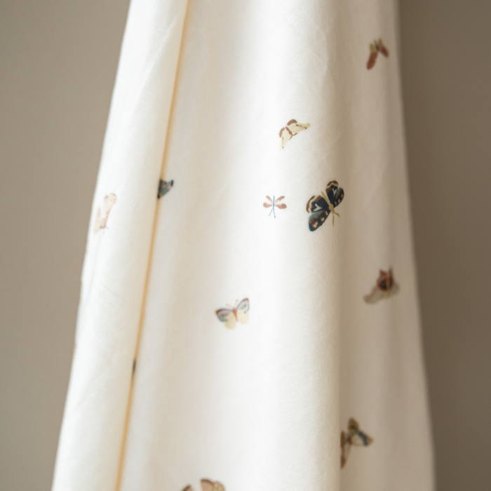 A minky stretch luxe swaddle that has a butterfly pattern on it.
