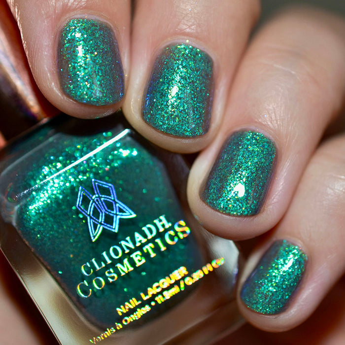 Close-up of nails painted with Nucleus Accumbens Nail Lacquer on fair skin tone. Hand is holding polish bottle.