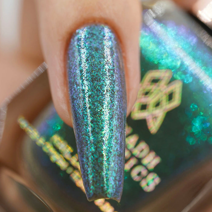 Close-up of one nail painted with Nucleus Accumbens Nail Lacquer on fair skin tone. Blurred polish bottle in background.