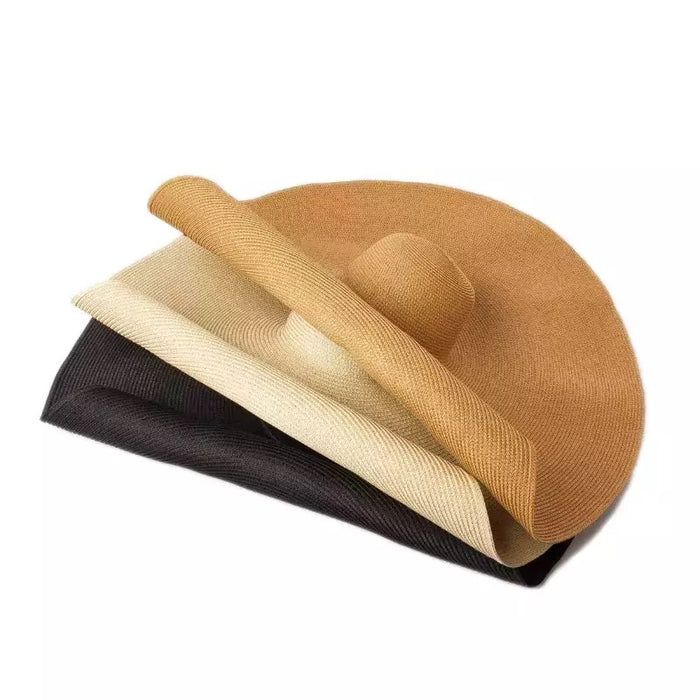 Stack of oversized straw sun hat in tan beige and black from Travellers Hat Boutique