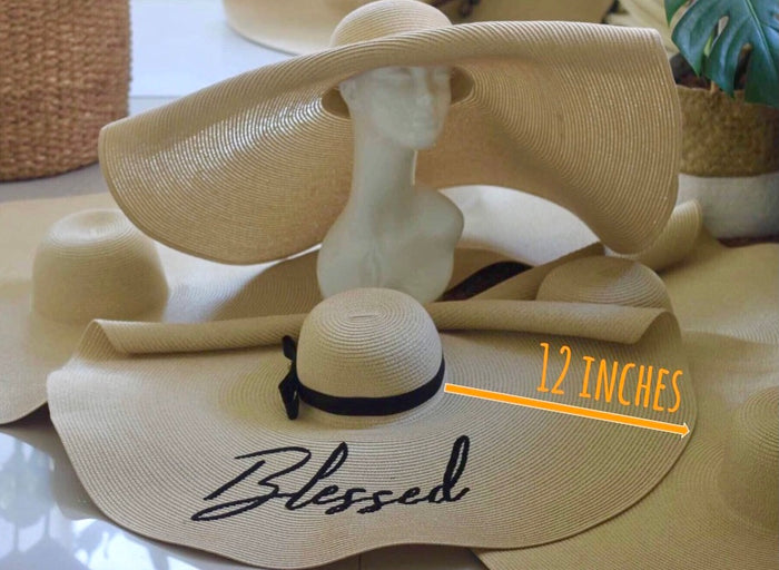 Oversized straw sun hat with a 12 inch wide brim and black ribbon detail from Travellers Hat Boutique