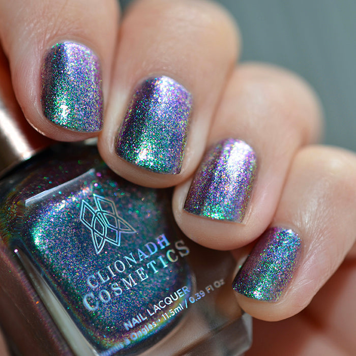Close up shot of nails done with Oxidize nail lacquer on light skin tone holding a nail polish bottle