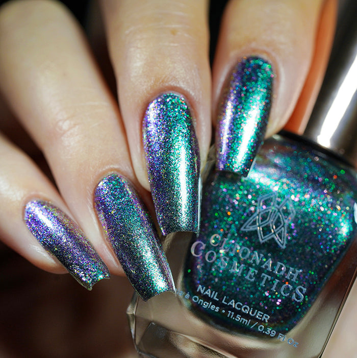 Close up shot of nails done with Oxidize nail lacquer on fair skin tone holding the nail lacquer bottle