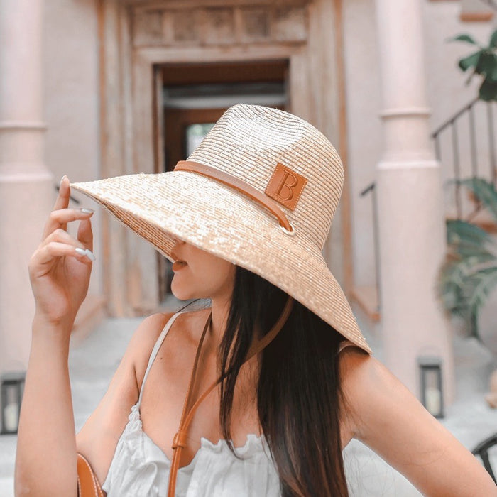 Woman wearing a panama wheat hat with wide brim and leather band from Travellers Hat Boutique