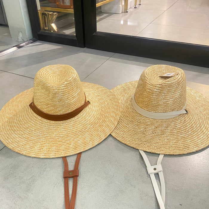Two panama wheat hats with wide brims and chin straps in brown and white from Travellers Hat Boutique