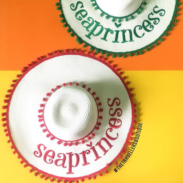 Custom floppy hat with pompoms from Travellers Hat Boutique, white with red and green pompom trims and seaprincess text