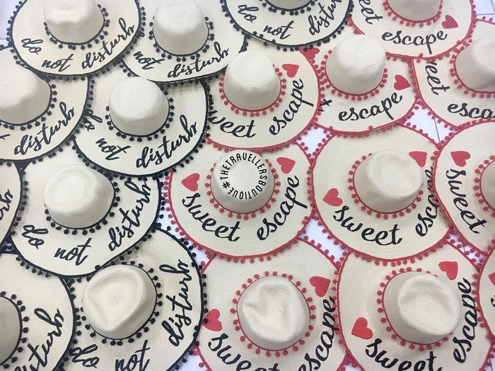 Custom floppy hat with pompoms in white featuring sweet escape and do not disturb text designs