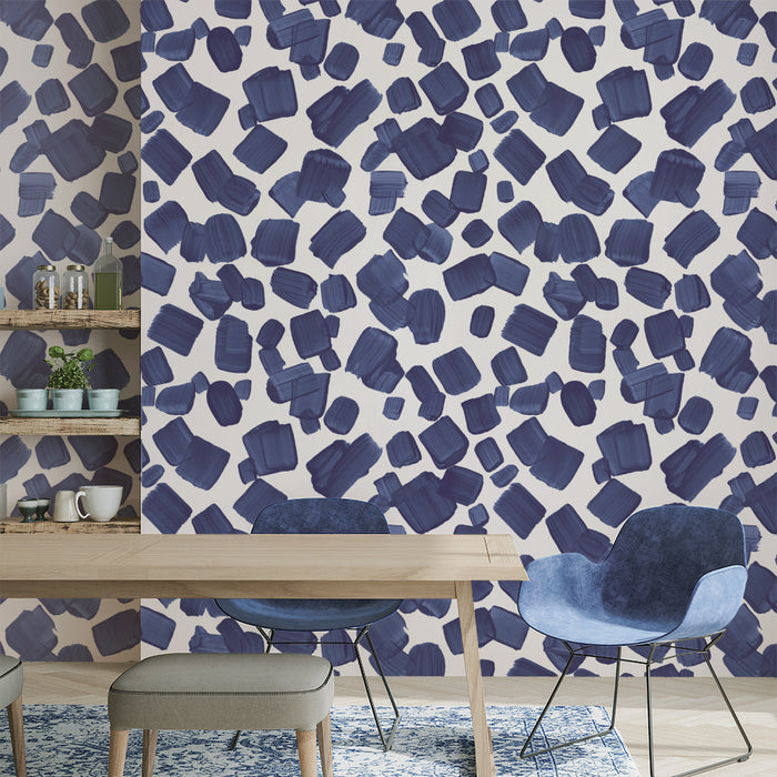 A dining area with a feature wall showcasing a custom wallpaper print made of blue paint marks.