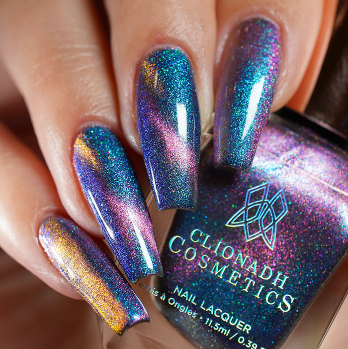 Close-up of nails painted with Psilocin Nail Lacquer on fair skin tone. Hand is holding polish bottle.