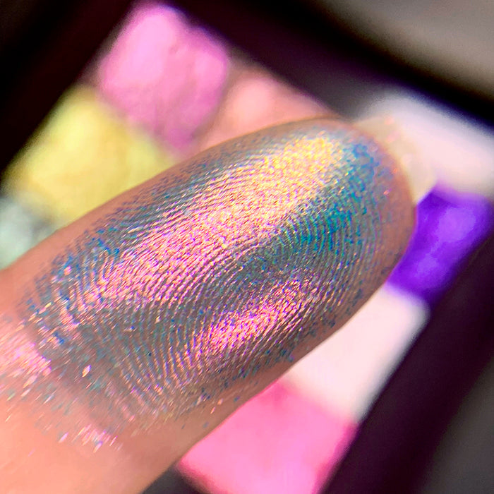 Close-up finger swatch of the eyeshadow Rex on fair skin tone.