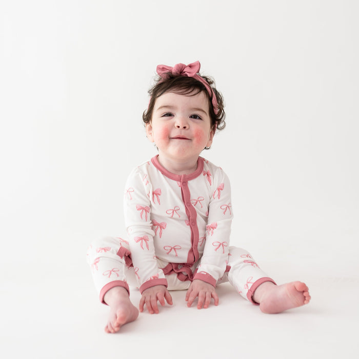 Toddler girl wearing Romper in Bow and Apple Blossom bow