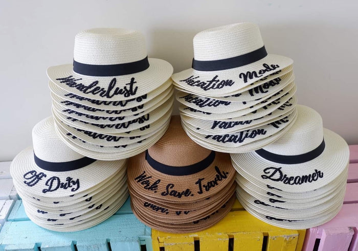 Custom embroidered round hat collection by Travellers Hat Boutique with various text designs and colors