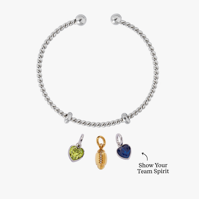 Silver bracelet with three charms on a white background