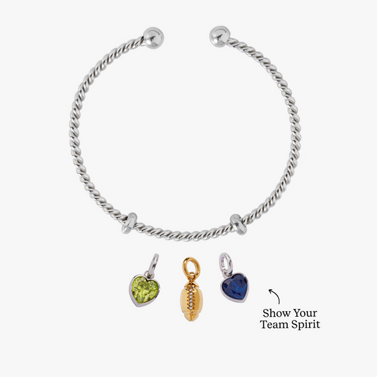 Silver bracelet with three charms on a white background