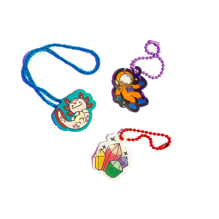 Group of completed charms from the OOLY Glow Buddies Shrink-Its! DIY Shrink Art Kit