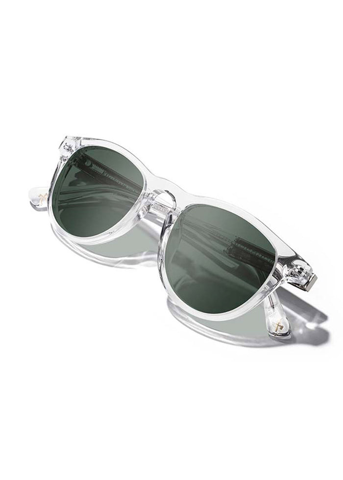 Clear-framed sunglasses with dark lenses on a white background, casting a soft shadow.