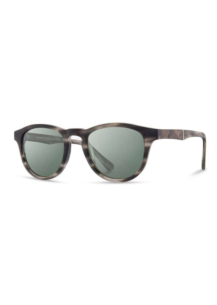 Stylish sunglasses with round, dark lenses and a sleek, tortoiseshell frame, angled slightly to the left against a white background.