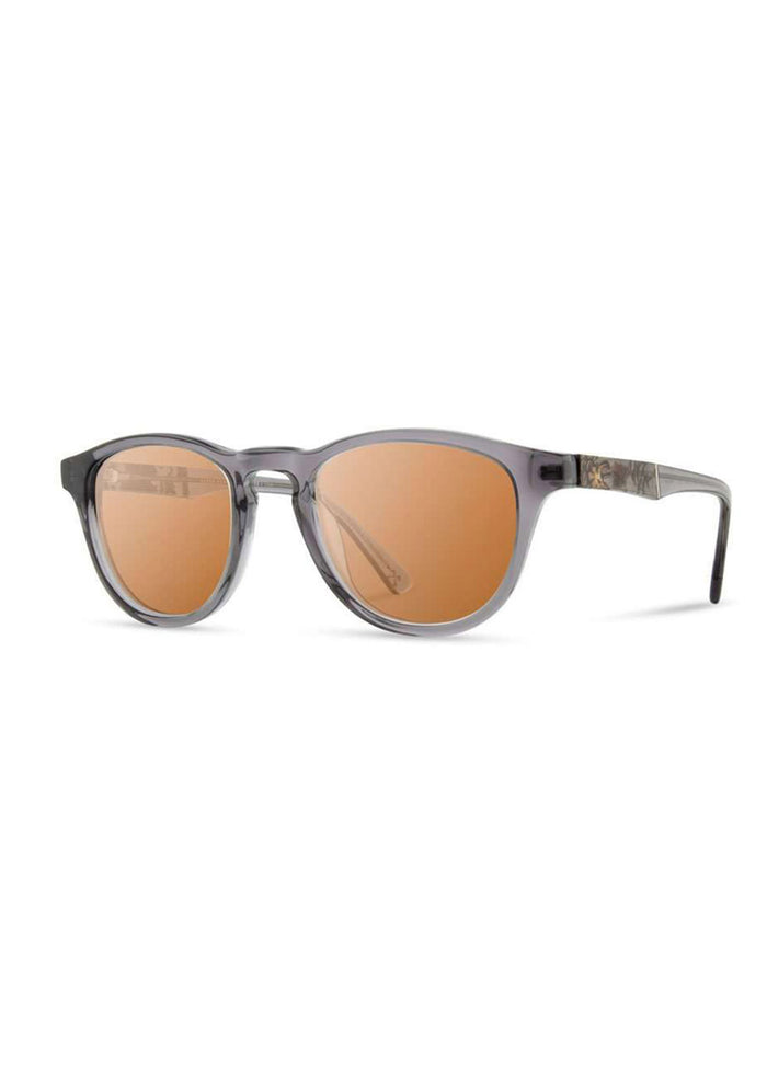 Stylish sunglasses with round, orange-tinted lenses and sleek, transparent gray frames, perfect for sunny days.