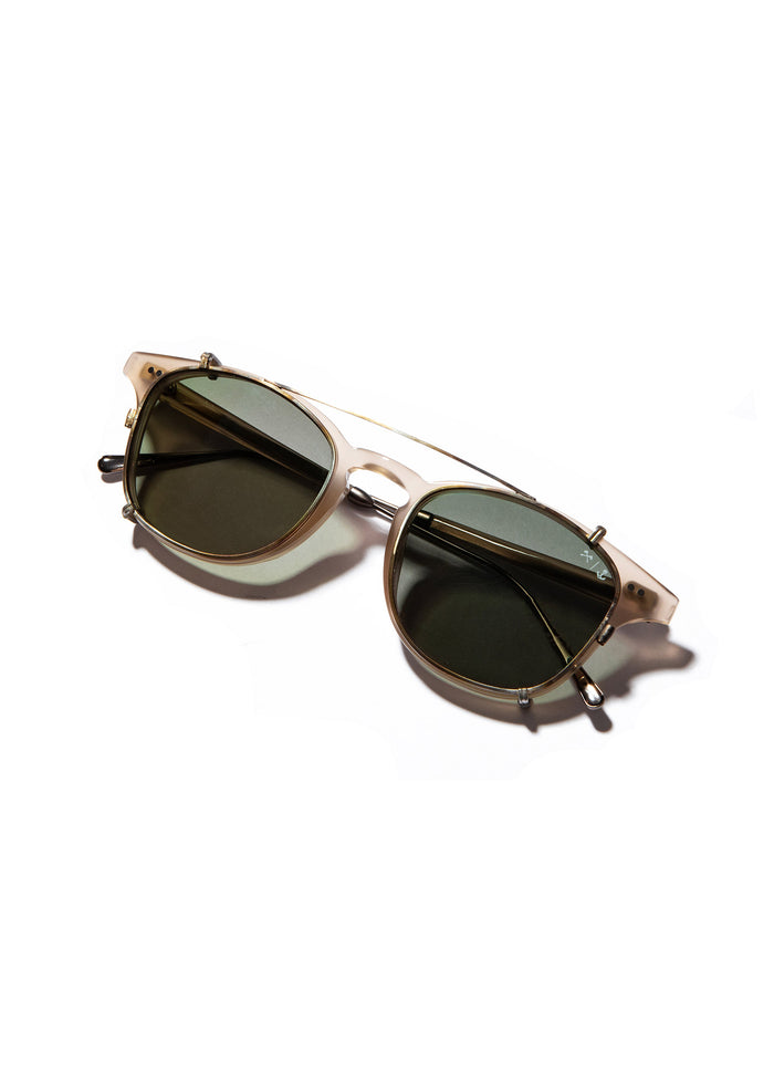 Stylish sunglasses with round, dark lenses and a sleek gold frame on a white background, casting a soft shadow.