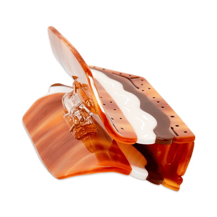 A side angle of the XO Marshmallow s'mores hair claw clip showing the clasp and teeth detail of the clip.