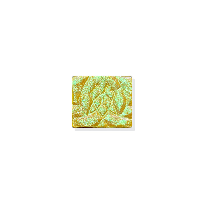 A single multichrome eyeshadow in colour Solarium on a white background. A yellow base with small particle shimmer that shifts bright green-icy blue-indigo.