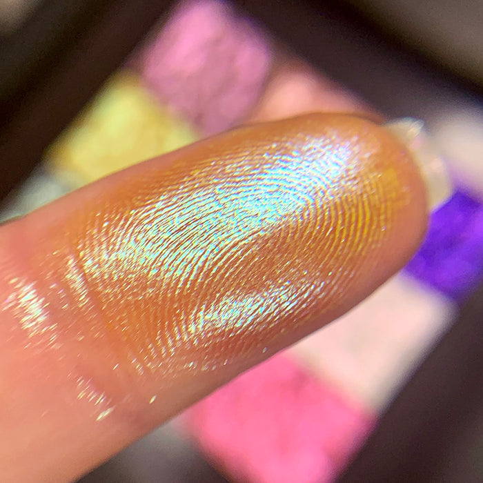 Close-up finger swatch of the eyeshadow Solarium on fair skin tone.