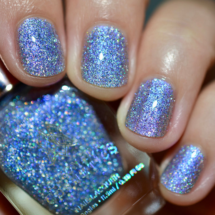 Close-up of nails painted with Spilled Salt Nail Lacquer on fair skin tone. Hand is holding polish bottle.