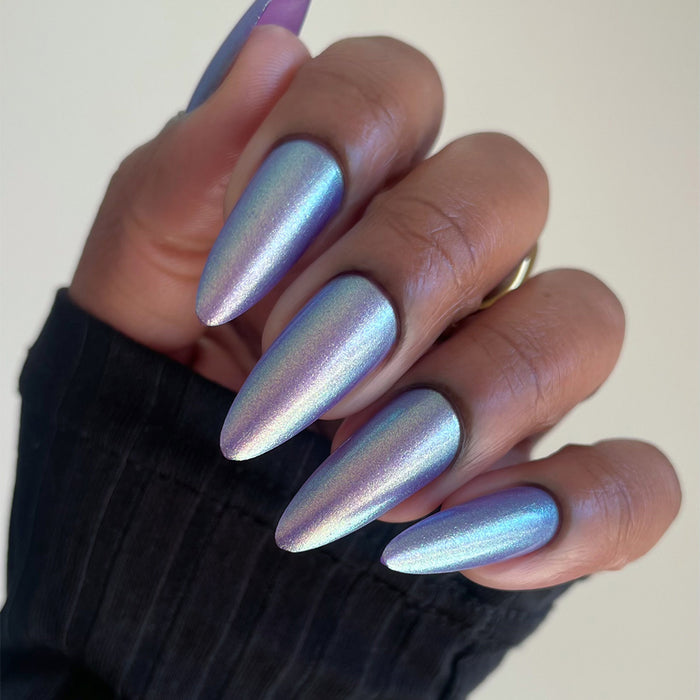 Close-up of nails painted with Royalty Nail Lacquer on deep skin tone, on a beige background.