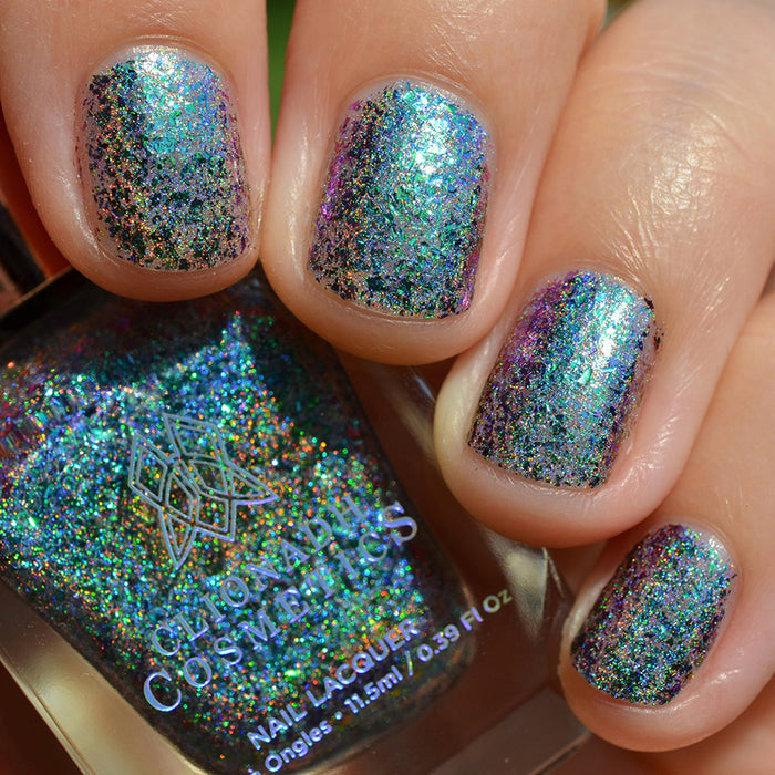 Close-up of nails painted with Step on a Crack Nail Lacquer on fair skin tone. Hand is holding polish bottle.