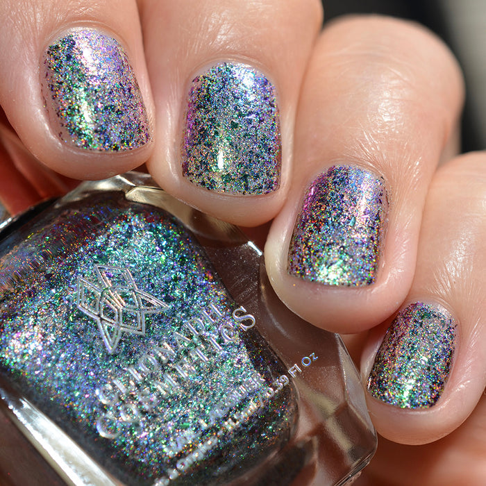 Close-up of nails painted with Step on a Crack Nail Lacquer on fair skin tone. Hand is holding polish bottle.