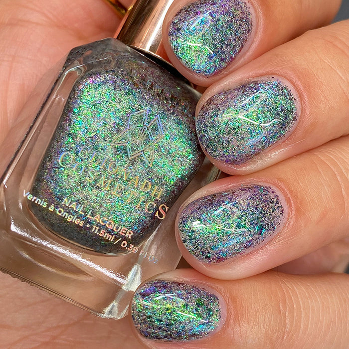 Close-up of nails painted with Step on a Crack Nail Lacquer on fair skin tone. Hand is holding polish bottle.