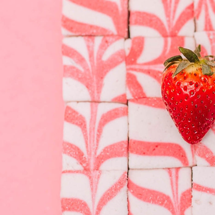 A close up photo of the pink and white swirled detail on the top of the XO Marshmallow homemade strawberry cheesecake marshmallows.
