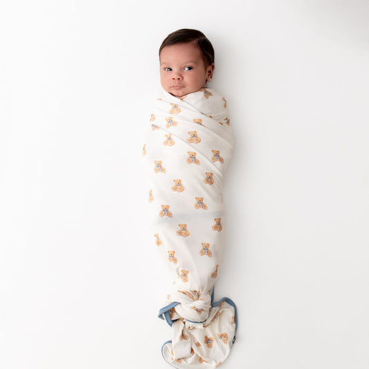 Baby wrapped in a teddy bear printed swaddle