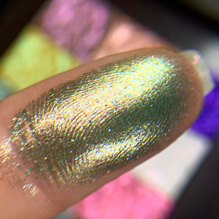Close-up finger swatch of the eyeshadow Synthesis on fair skin tone.