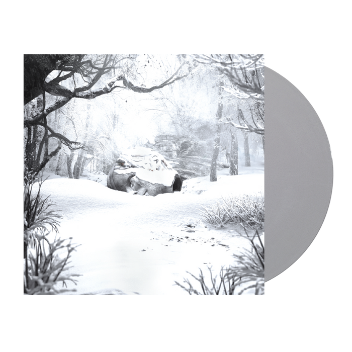 Snow-covered winter forest scene with bare trees and a rock formation.