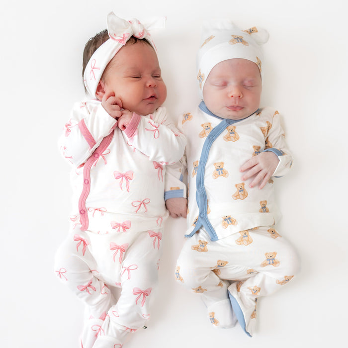 2 babies in take me home sets in a bow pattern and teddy bear pattern