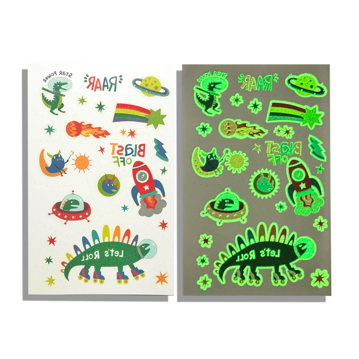 Comparative side by side image of OOLY Tattoo-Palooza Glow in the Dark Temporary Tattoos - Zero Gravity Dinos sheet in regular light and glow in the dark