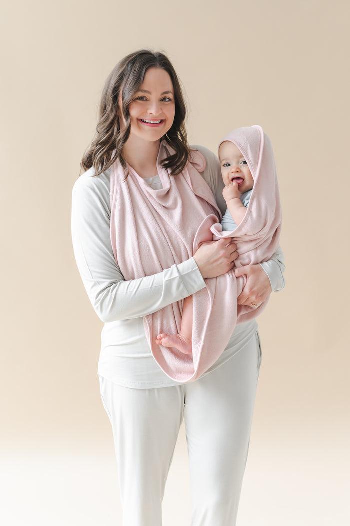 Mother holding her infant child wrapped in the Terry Apron Towel in Blush