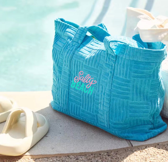 Turquoise terry cloth beach tote bag with Salty Beach text, perfect for summer by Travellers Hat Boutique