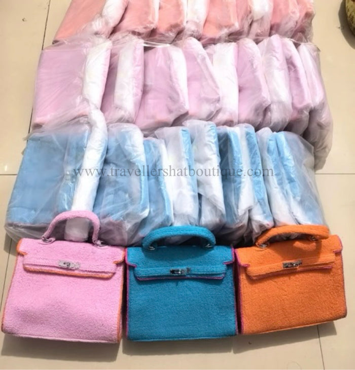 Terry cloth handbag tote bags in pink blue and orange by Travellers Hat Boutique stacked and wrapped in plastic