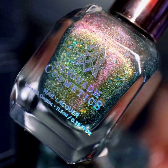 Angled, close- up of Th1rt3en Nail Lacquer bottle, on a dark blurred background.