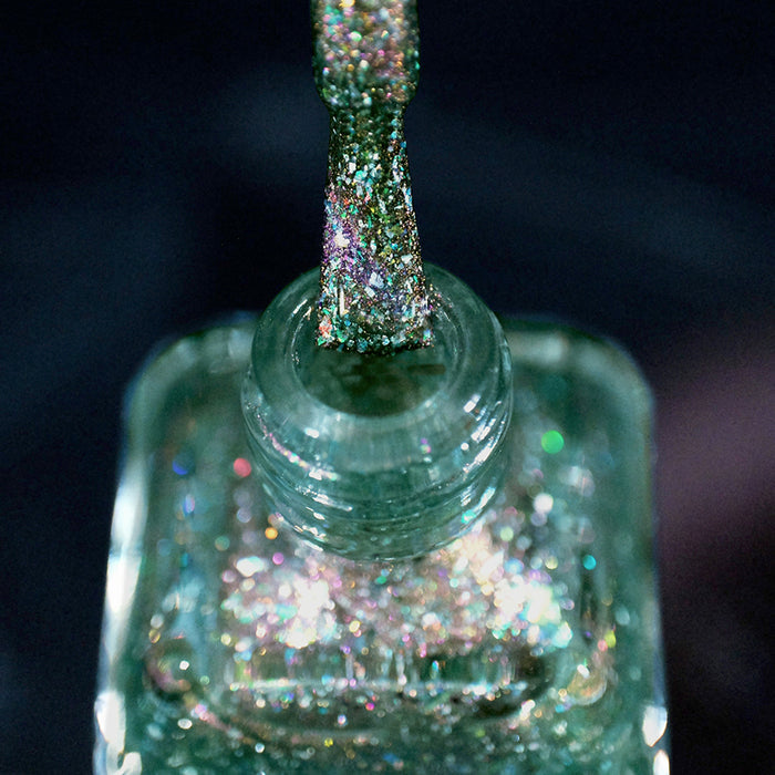Close-up of nail polish bottle and brush showing product Th1rt3en Nail Lacquer, on a dark blurred background.