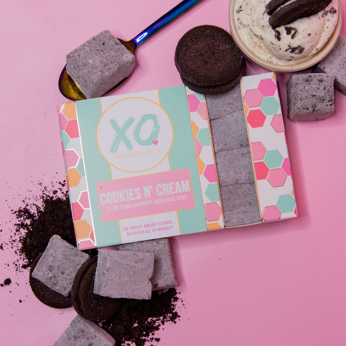 A box of XO Marshmallow Cookies and Cream marshmallows with more marshmallows and gluten free oreos around it