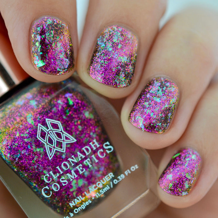 Close-up of nails painted with Pholiotina Nail Lacquer on fair skin tone. Hand is holding polish bottle.