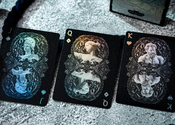 Three tarot cards with intricate designs on a textured surface