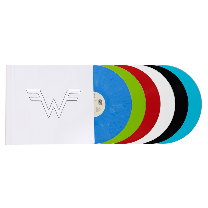 A vibrant multi-colored vinyl record set featuring five translucent discs in blue, green, red, white, and black, housed in a minimalist white sleeve with a stylized ’w’ logo.