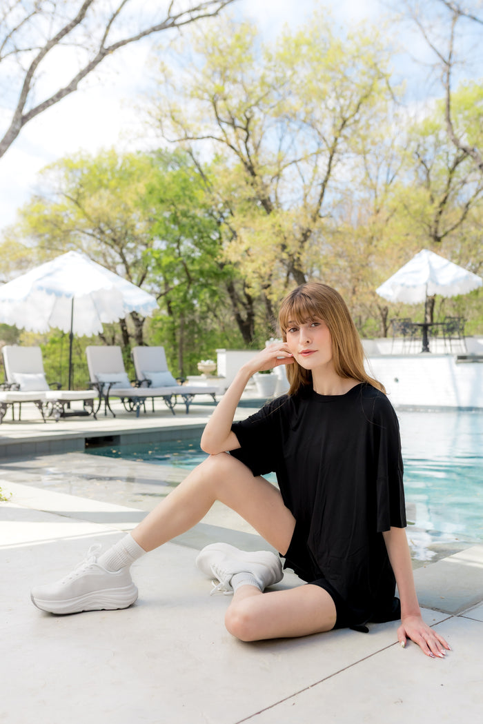 Female sitting by the pool's edge wearing the Women’s Biker Short Set in Midnight