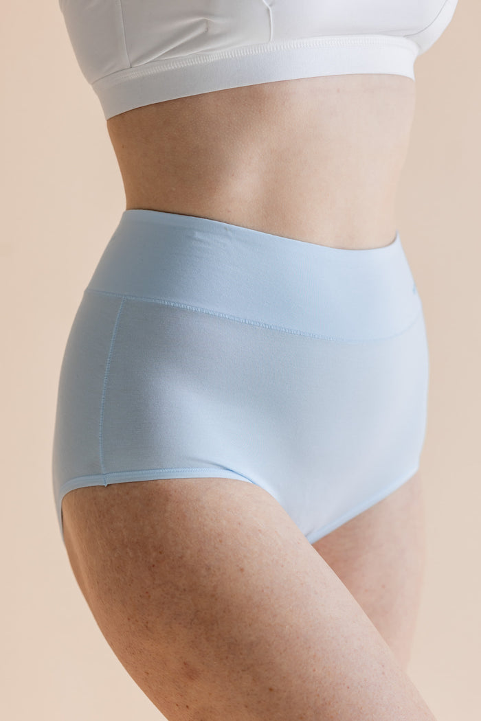 Light blue underwear worn by a person on a beige background
